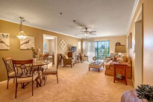 Interior or a Covenant Living of Samarkand apartment with dining and living area that leads to large glass doors and patio